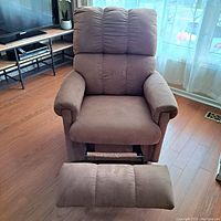 Front view of brown rocker recliner chair with footrest extended showing padded seat and armrests.