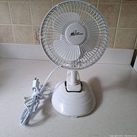 Front view of small white clip-on desk fan showing RS Speed Control System logo, fan blades, and power cord.