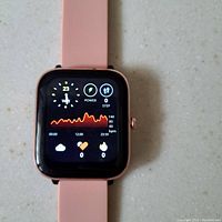 Front view of pink smart watch display showing heart rate graph, power, and steps data