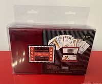 Photo showing front of red wood box sealed in clear plastic wrap with a sticker picture of 32 first day covers and the commemorative plaque inside.