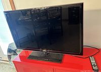 Front view of the Samsung 40-inch LED TV displaying screen and stand, showing overall physical condition and glossy black bezel.
