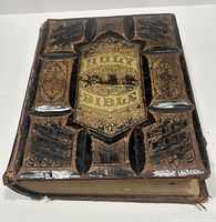 Front cover close-up showing detailed embossed leather with gold lettering 'Holy Bible' and intricate decorative patterns.