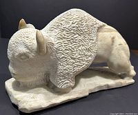 Angled side view showing full left profile of buffalo on base