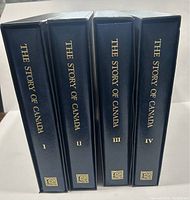Four navy binders with gilt titles The Story of Canada I, II, III, IV on spines