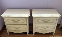 Pair of vintage French Provincial nightstands side by side, showing front view with two drawers, white and gold accents.