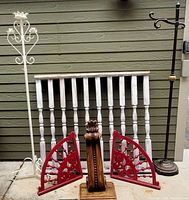 Entire lot of architectural salvage items including two metal coat racks, a wood spindle panel, two red decorative brackets and a carved wood piece.