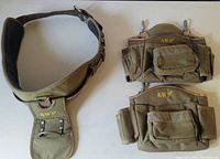 Full overview of the three AWP tool belt pieces laid out. Shows the main padded belt and two pouches with multiple compartments and loops for tools.