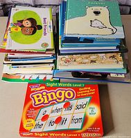 Top view of stacked children's books with visible covers 'Forever' and 'Best Friends' and Sight Words Bingo game in front