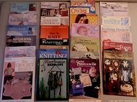 Top view of 19 craft books arranged in rows showing knitting, crochet, and crafting themes.