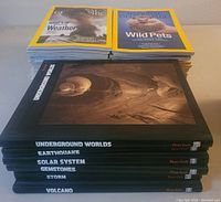 Stack of National Geographic magazines on top and six Time Life hardcover books with black covers underneath, titles visible