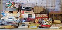 Wide view of fabric pieces, sewing thread tins, kits, patterns, and storage baskets