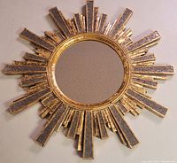 Full view of the circular mirror and sunburst frame with gold and mirrored segments