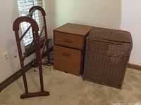 Photo showing wooden file cabinet, wicker hamper, and wooden quilt rack placed against a wall near a window.