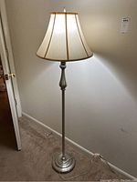Full view of floor lamp showing fabric shade and metal pole.
