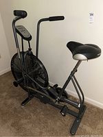 Side view of Schwinn Airdyne exercise bike showing fan wheel, pedals, and dual-action handlebars.