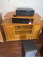Full front view of wooden stereo cabinet with equipment on Lazy-Susan top and inside shelving compartments