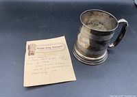 Antique silver beer mug with handwritten notes on antique provenance