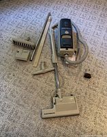 Full view of the Electrolux Diplomat vacuum cleaner powerhead and multiple cleaning attachments spread on carpet