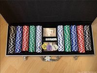 Open silver suitcase displaying poker chip stacks, dice, and dealer chips inside
