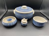 7 pottery pieces in blue and white with decorative patterns arranged in a group