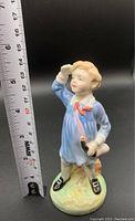 Full view of the Royal Doulton Little Boy Blue porcelain figurine alongside a measuring tape showing a height of approximately 5.5 inches.