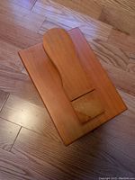 Top view of wooden shoe shine box showing the curved handle on lid.