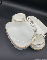 White china tea tray with compartments for sugar and creamer, white with gold trim, featuring a handle for carrying.