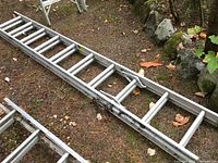 Aluminum extension ladder extended on ground, showing medium weight frame and rungs.