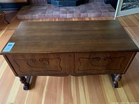 Full top and front view of the cedar chest showing the rectangular hinged lid and carved swirl pattern on front panels.