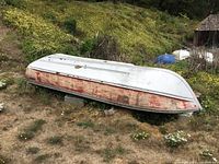 Upside-down view of entire boat showing hull shape and paint wear