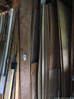 Stack of mixed wood sheets leaning against wall