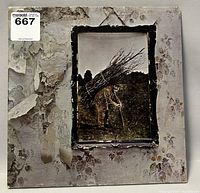 Front cover of Led Zeppelin IV album with iconic artwork of a man carrying sticks on a peeling wall background