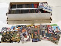 Photo of large box with two rows of baseball cards stored vertically in sleeves, with sample cards displayed in front