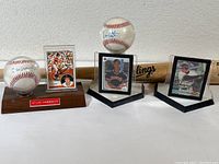 Three autographed baseballs each paired with player cards on stands; Atlee Hammaker ball in wooden stand, two others in plastic holders; Darren Lewis ball stand missing pedestal
