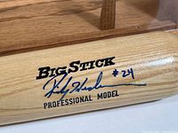 Close-up of bat barrel showing “Big Stick PROFESSIONAL MODEL” branding and Rickey Henderson blue ink signature with “#24”