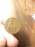 Reverse of 1929 English half penny showing Britannia seated with shield and trident, inscription 'HALF PENNY' and year '1929'.