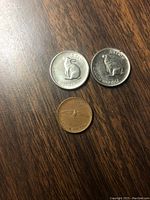 Reverse side of two Canadian 1967 5-cent nickel coins showing rabbit design and one penny 1-cent coin showing Canada goose in flight, with 'Canada 1867-1967' text.