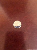 Blue tinted reverse side of the 2021 U.S. dime coin showing torch, olive branch, and oak branch design.