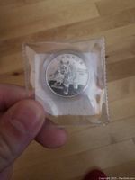Photo of front side of sealed Canadian $20 silver bobcat coin showing design and denomination.