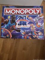 Front view of the Monopoly game box featuring Space Jam: A New Legacy characters and logo, highlighting the basketball theme and age recommendation (8+).