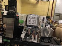 Photo of lot showing stainless steel 4-slice toaster, rice cooker behind it and part of coffee maker.