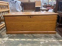 Front view of wooden blanket chest showing smooth finish and dovetailed corner joints.
