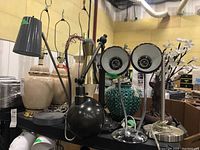 Wide view of the lot showing multiple table and desk lamps in metal, ceramic and plastic.