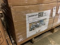 Photo of sealed cardboard box wrapped with plastic showing label indicating it contains assorted mugs in various sizes, shapes, and colors.