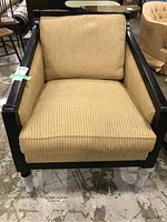 Front view of the Jessica Charles occasional chair showing the wood frame and textured light brown upholstery with cushion.