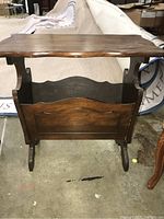 Front view of the vintage solid wood side table showing the top surface and integrated magazine rack below.