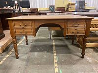 Front view of desk showing six drawers and turned spindle legs