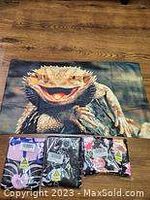 Photo of lizard hand towel with three additional packaged character-themed towels on wooden floor