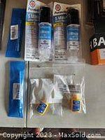 Photo of multiple Loctite branded industrial adhesive bottles and small tubes arranged on a flat surface