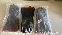 Three pairs of gloves arranged flat on a surface; middle pair is black heavy duty BBQ gloves with red cuff trim, flanked by two pairs of black rubber gloves each individually packaged in plastic.